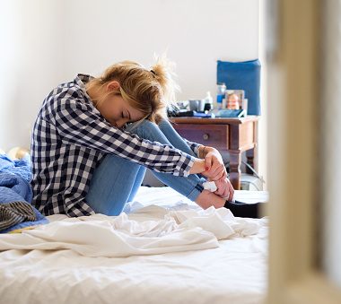 Young woman crying in bed