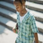 Young boy walking down steps with headphones in
